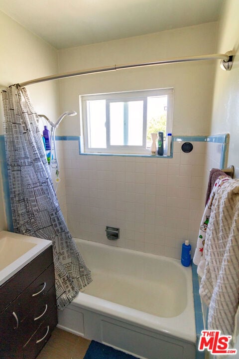 bathroom featuring vanity and shower / bath combination with curtain