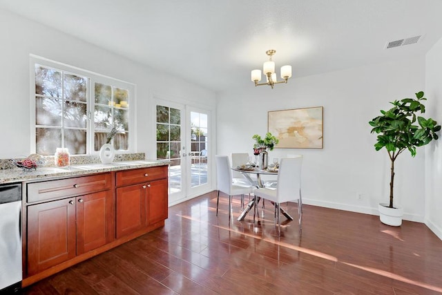 kitchen with light stone counters, dark wood-type flooring, stainless steel dishwasher, and french doors