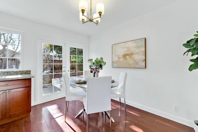 dining space featuring dark wood-type flooring, an inviting chandelier, and french doors