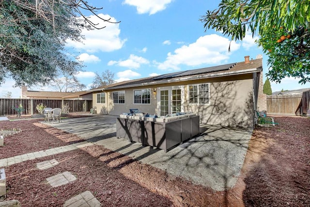 rear view of property with outdoor lounge area, a patio area, and solar panels