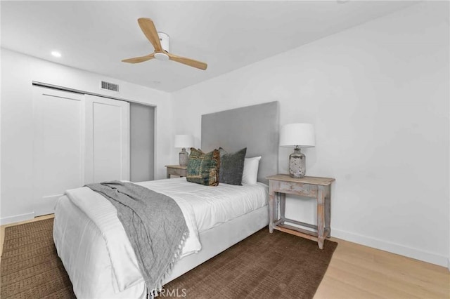 bedroom featuring ceiling fan, dark hardwood / wood-style floors, and a closet