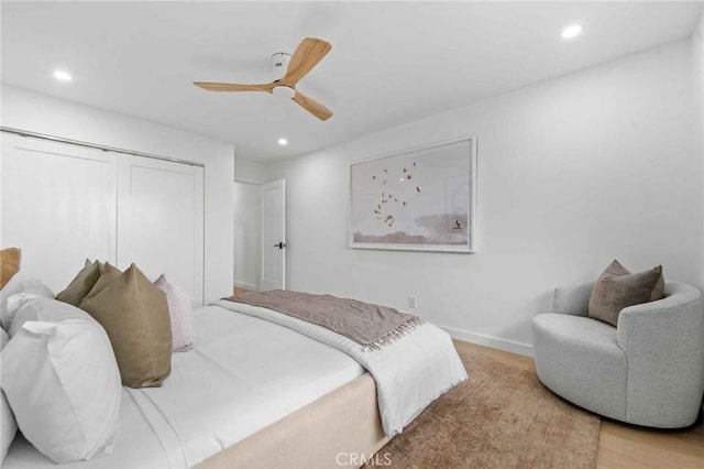 bedroom featuring ceiling fan, a closet, and light hardwood / wood-style flooring