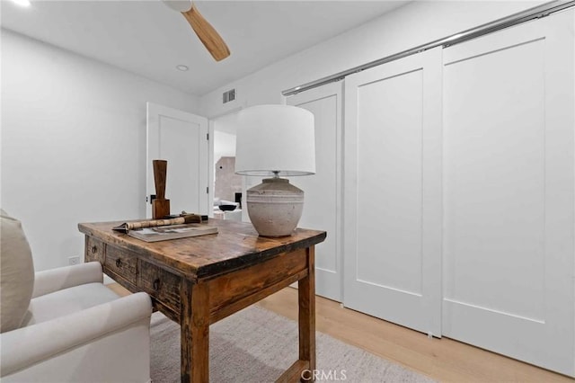 home office featuring light hardwood / wood-style floors and ceiling fan