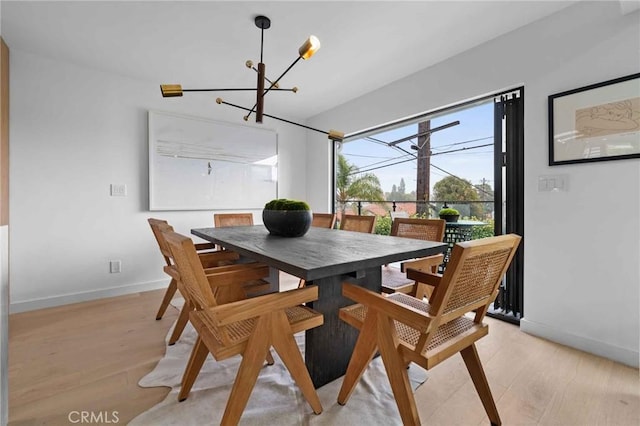 dining space with an inviting chandelier and light hardwood / wood-style flooring