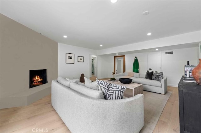 living room with a fireplace and light hardwood / wood-style floors