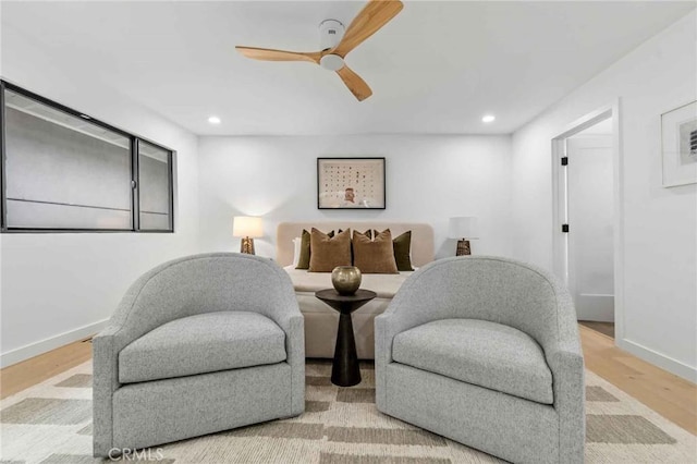 living area with light hardwood / wood-style flooring and ceiling fan