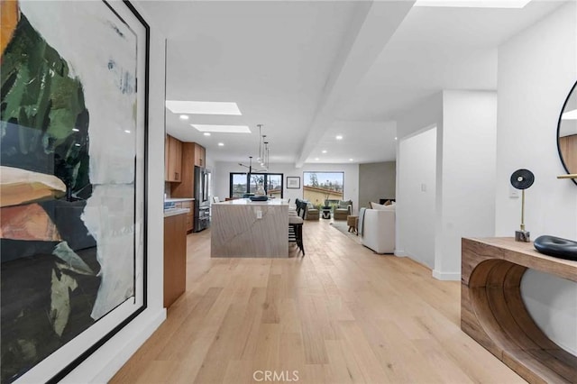 hall featuring a skylight and light wood-type flooring