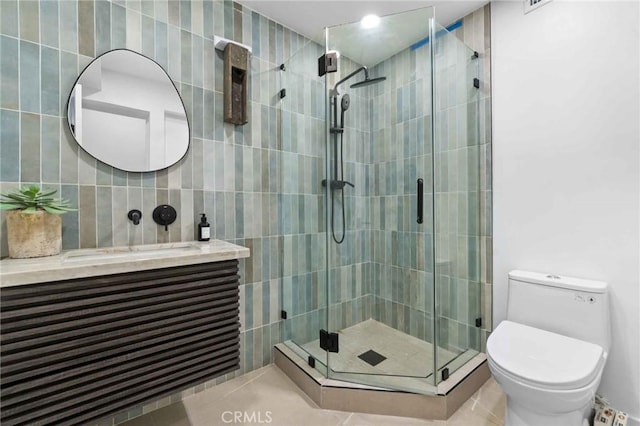 bathroom featuring vanity, toilet, and an enclosed shower