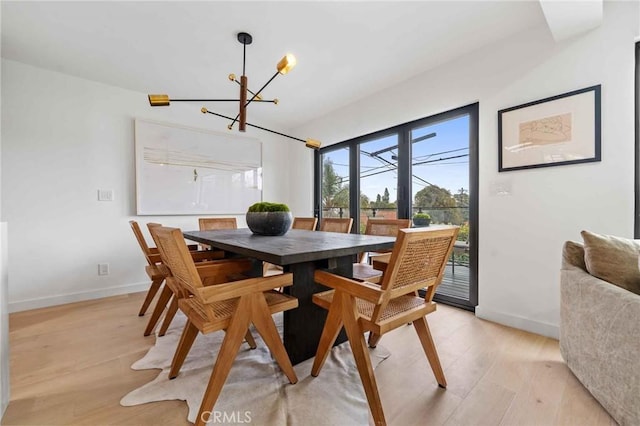 dining area with a notable chandelier and light wood-type flooring