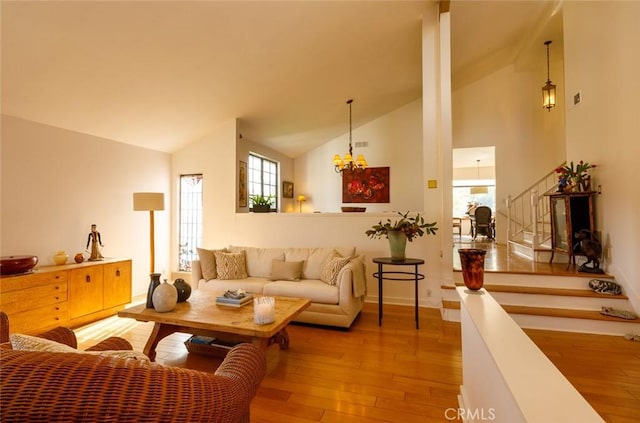 living room featuring an inviting chandelier, hardwood / wood-style floors, and high vaulted ceiling