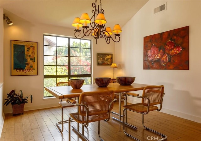 dining area with an inviting chandelier, lofted ceiling, a wealth of natural light, and light wood-type flooring