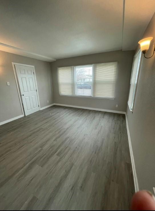 unfurnished living room with dark wood-type flooring