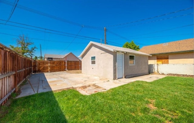 rear view of house with a patio area and a lawn