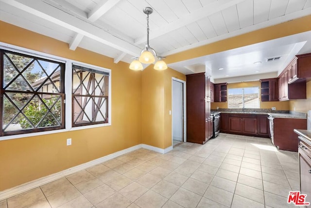 kitchen with light tile patterned flooring, beam ceiling, hanging light fixtures, and stainless steel gas stove