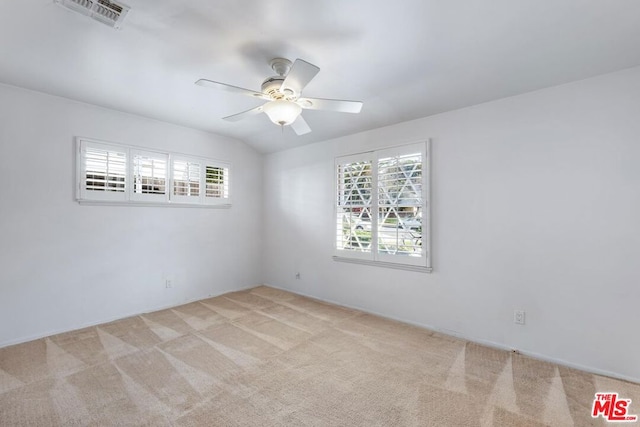 carpeted empty room featuring ceiling fan and vaulted ceiling