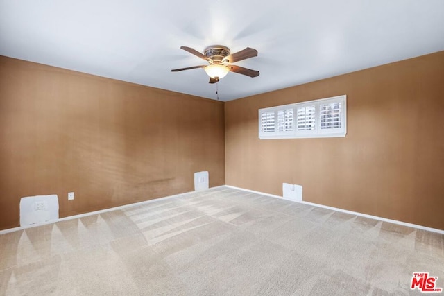 carpeted spare room featuring ceiling fan