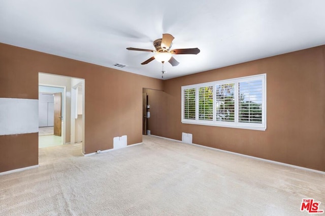 empty room featuring ceiling fan and light colored carpet