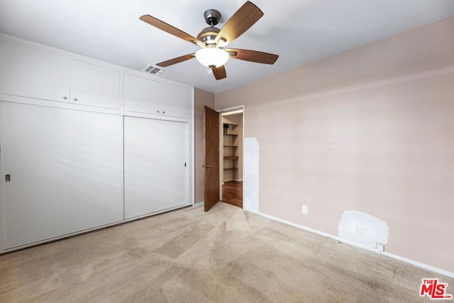 unfurnished bedroom with light carpet, ceiling fan, and a closet