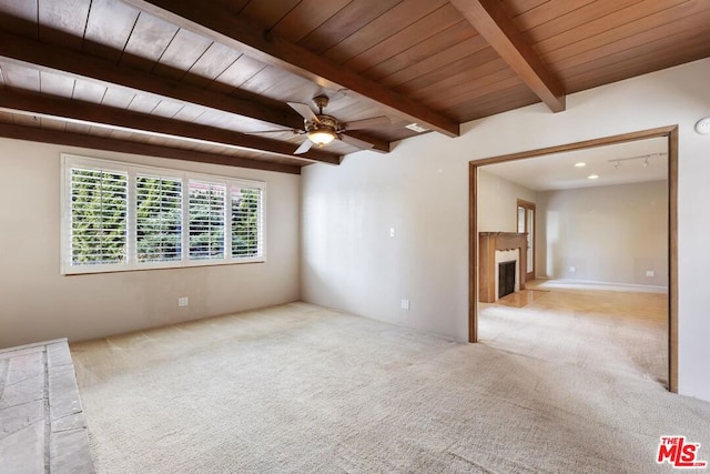 empty room featuring wood ceiling, light colored carpet, and beam ceiling