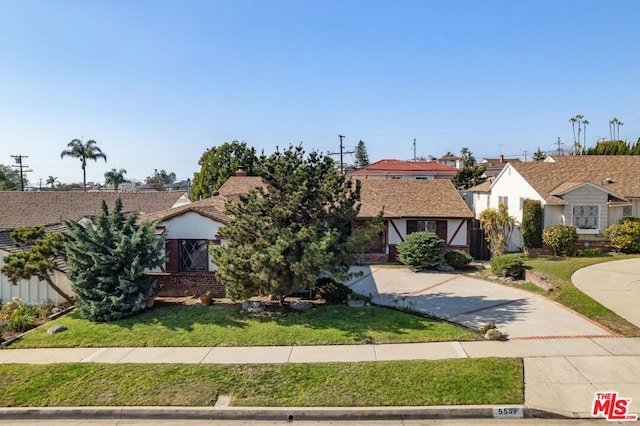 english style home with a front lawn