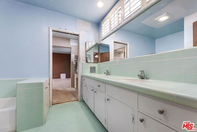 bathroom featuring vanity, decorative backsplash, and a tub