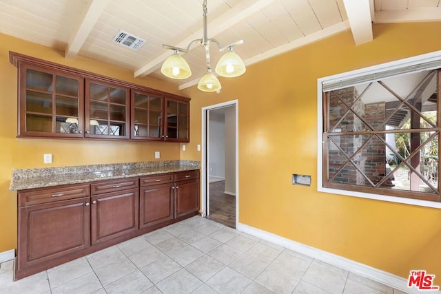 kitchen with hanging light fixtures, light tile patterned floors, a notable chandelier, light stone countertops, and beam ceiling