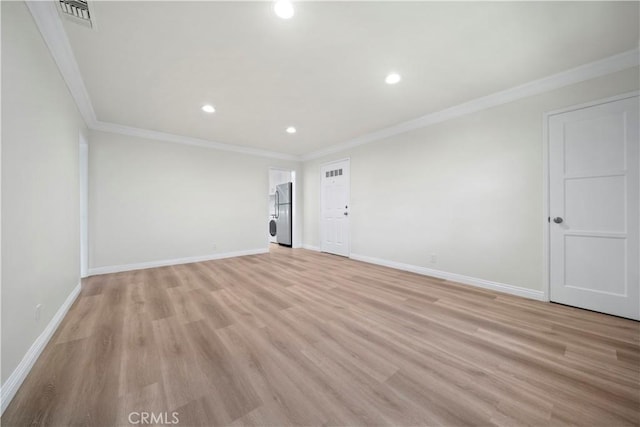 spare room featuring crown molding and light wood-type flooring