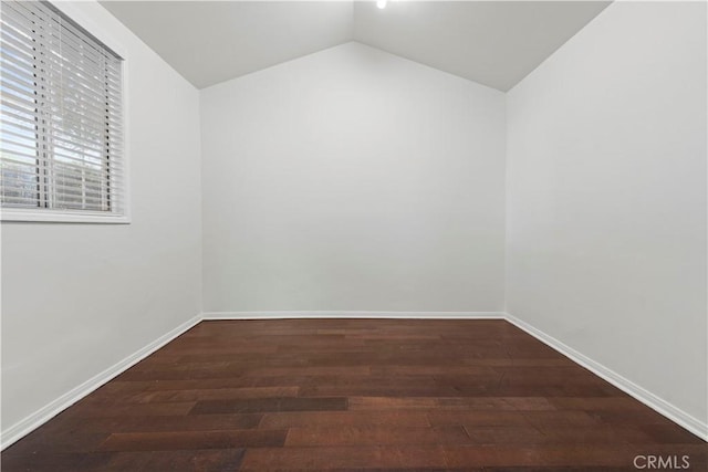 empty room featuring vaulted ceiling and dark hardwood / wood-style floors