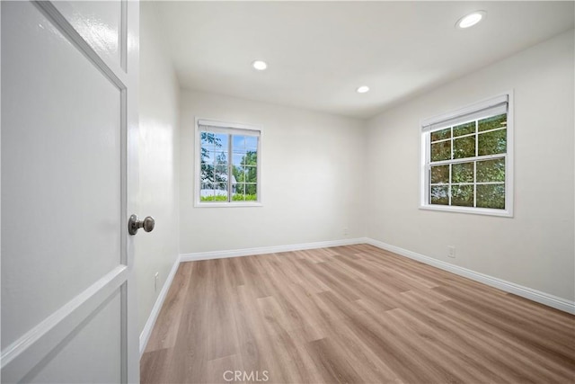 spare room featuring a healthy amount of sunlight and light hardwood / wood-style flooring