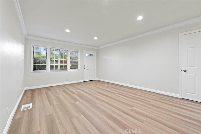 empty room featuring ornamental molding and light hardwood / wood-style flooring