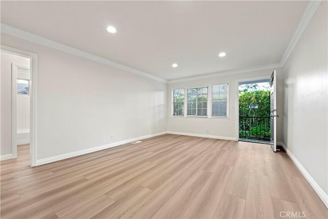 spare room featuring ornamental molding and light hardwood / wood-style floors