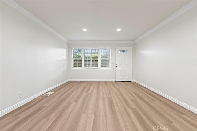 empty room featuring ornamental molding and light hardwood / wood-style floors