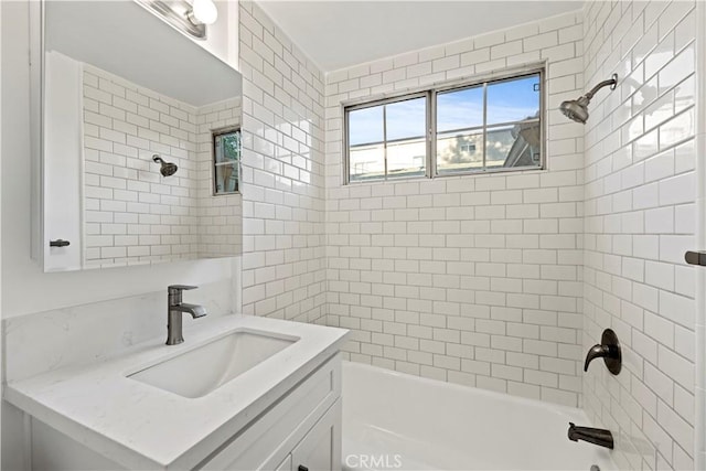 bathroom with tiled shower / bath and vanity