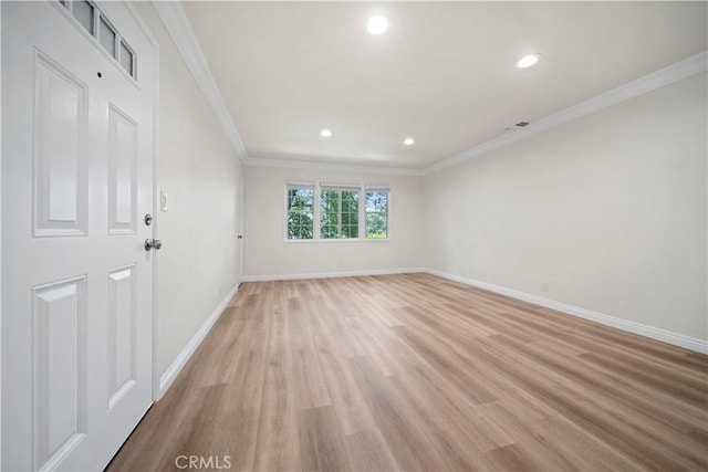 spare room with crown molding and light hardwood / wood-style flooring