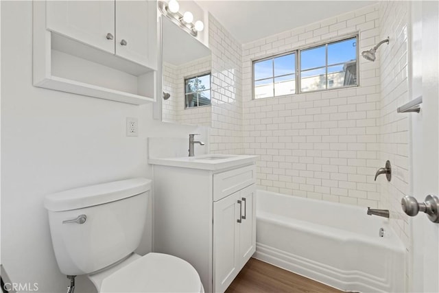 full bathroom with tiled shower / bath, vanity, toilet, and hardwood / wood-style floors