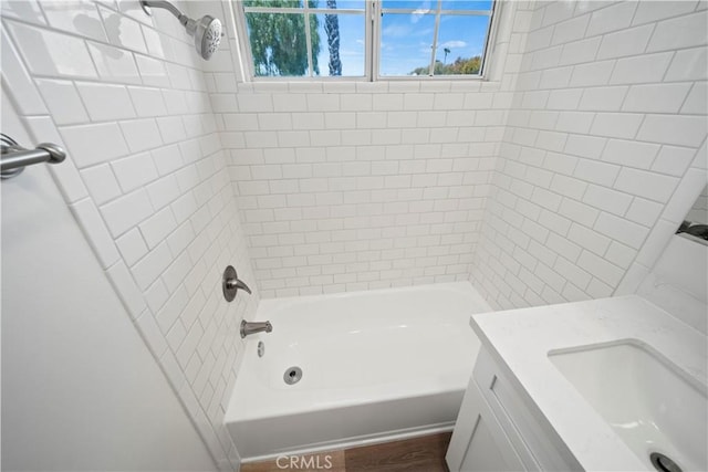 bathroom featuring tiled shower / bath combo and vanity