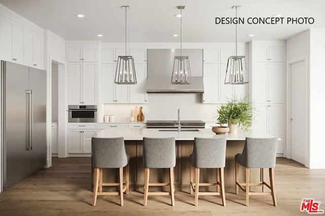 kitchen featuring appliances with stainless steel finishes, sink, white cabinets, hanging light fixtures, and a center island with sink