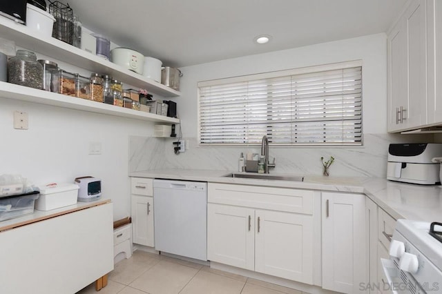 kitchen with sink, dishwasher, range, white cabinets, and light tile patterned flooring