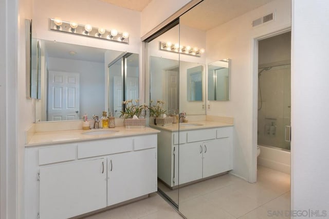 bathroom with tile patterned flooring, vanity, and combined bath / shower with glass door