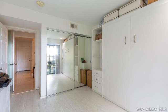 unfurnished bedroom featuring a closet and light hardwood / wood-style flooring