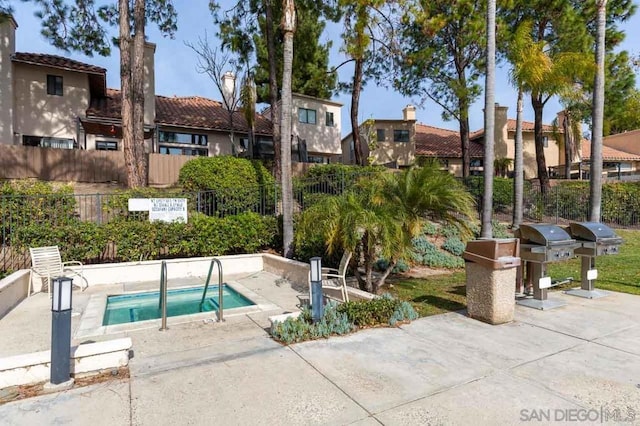 view of swimming pool with a grill, a hot tub, and a patio