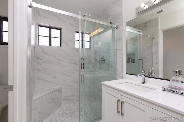 bathroom with a shower with door and vanity