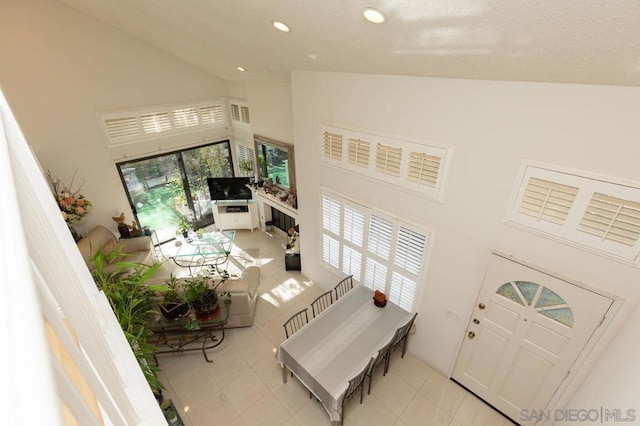 tiled living room featuring high vaulted ceiling