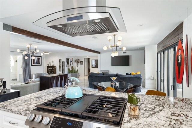 kitchen with white cabinetry, gas stove, light stone counters, and a notable chandelier