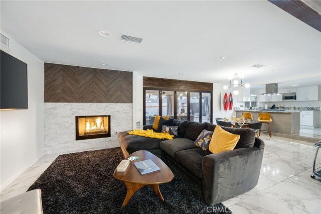 living room featuring a large fireplace and a chandelier