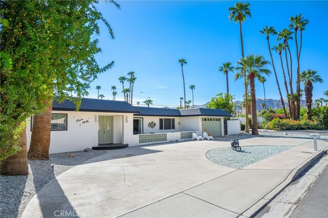 ranch-style home with a garage and solar panels