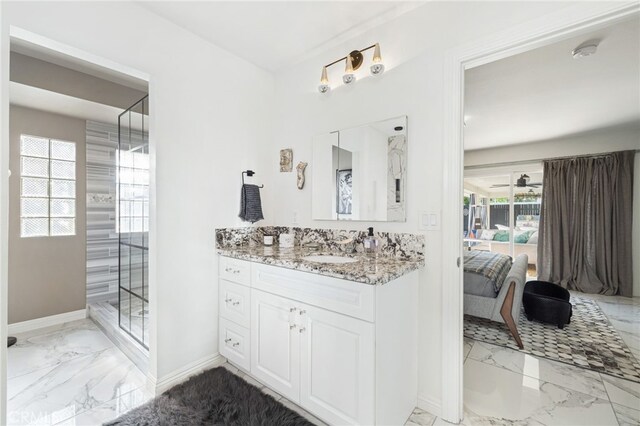 bathroom featuring vanity, a shower with shower door, and ceiling fan