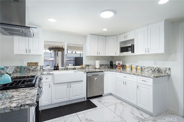 kitchen with white cabinetry, island exhaust hood, appliances with stainless steel finishes, and light stone counters