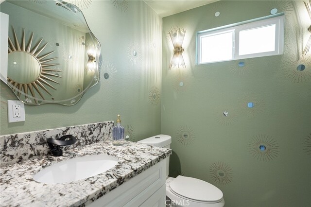 bathroom featuring vanity and toilet