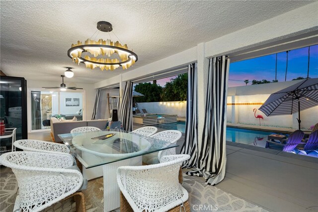 dining area with an inviting chandelier and a textured ceiling